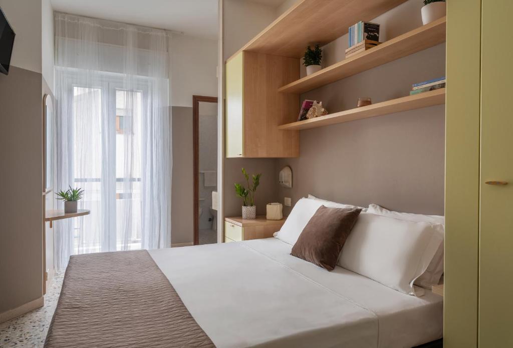 a bedroom with a large white bed and a window at Vibe Hotel in Cattolica