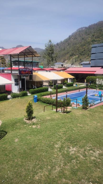a large swimming pool in front of a building at Down Valley Resort in Rishīkesh