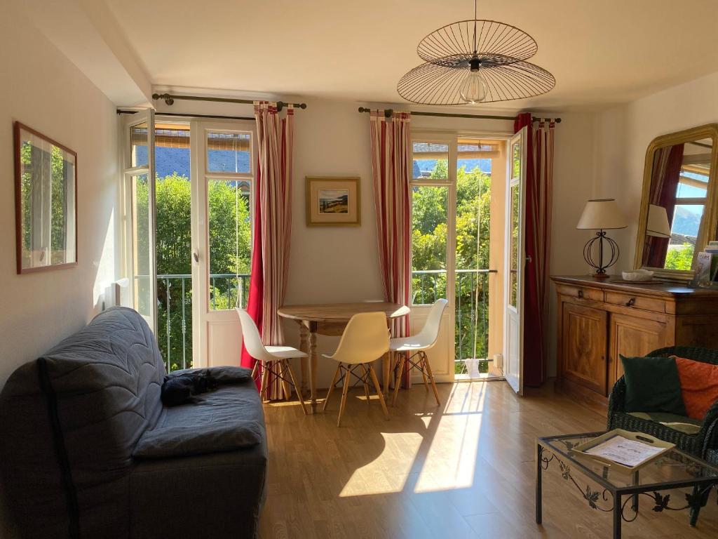 a living room with a couch and a table with chairs at T2 cosy centre ville in Luchon
