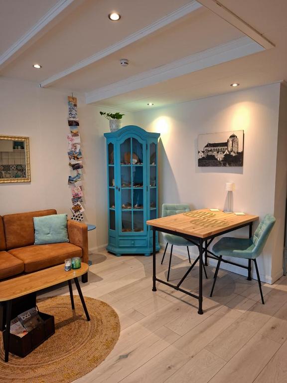 a living room with a table and a couch at Dulce Tierra - vakantiewoning in Zoutelande