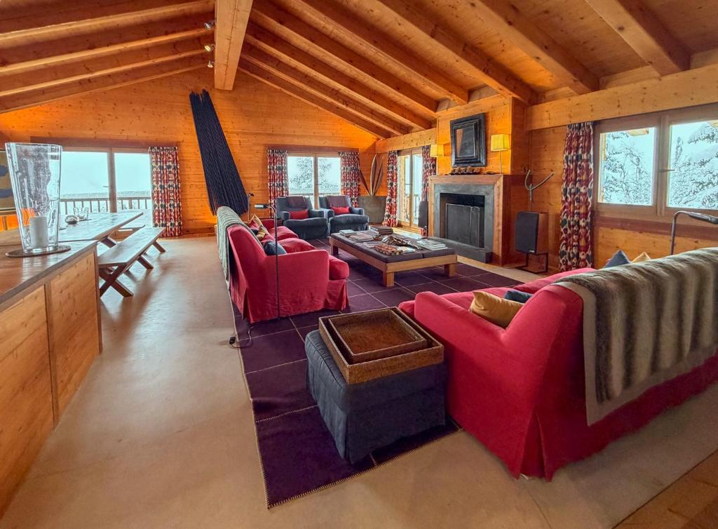 a living room with red couches and a fireplace at Chalet Sainfoin in Verbier