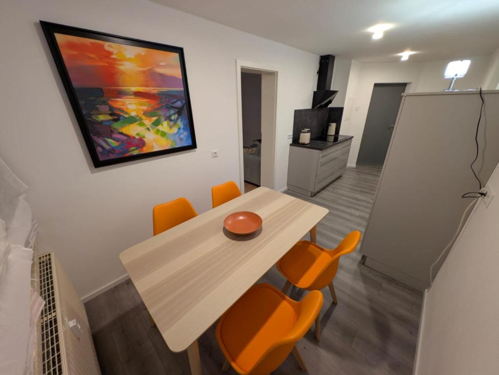 a dining room with a table and some orange chairs at Ferienwohnung Waldenburg Sachsen II in Waldenburg