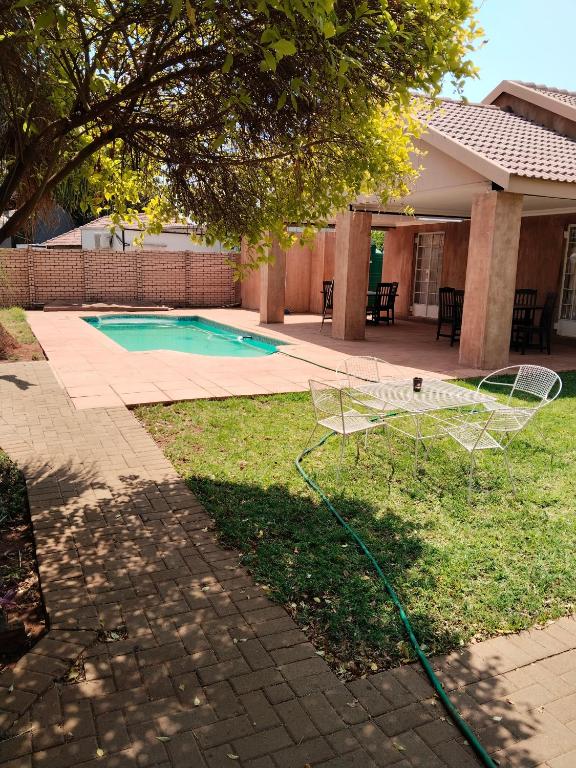 a net in the grass next to a swimming pool at Claypot Guesthouse in Northam