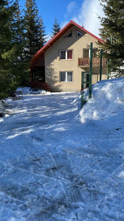 a house in the snow in front at Cabana Iubirii in Ranca