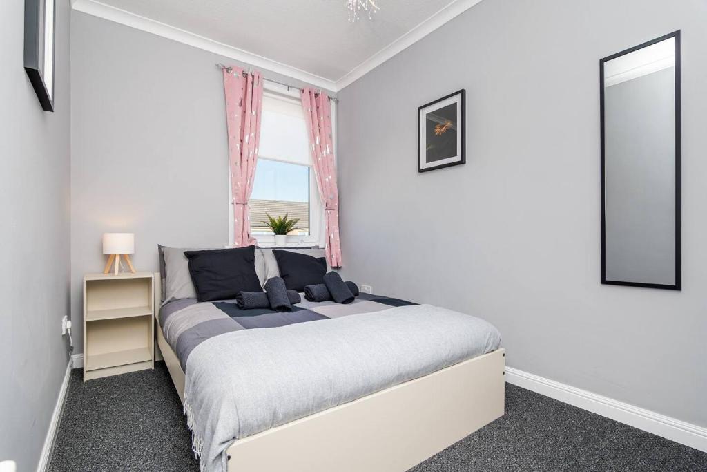 a bedroom with a large bed with a window at Ideal Work Stays 3BR 6 Guests Free Parking in Falkirk