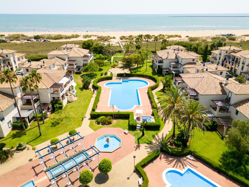 an aerial view of a resort with a pool and the beach at Leo San Bruno in Isla Canela