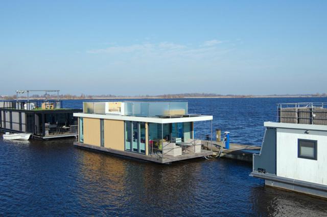 a house on a dock in a body of water at Houseboat Robbedoes in Offingawier