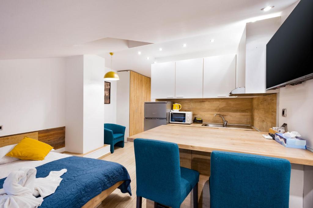 a kitchen with a table and blue chairs in a room at Apartments Pomerio Rijeka East in Rijeka