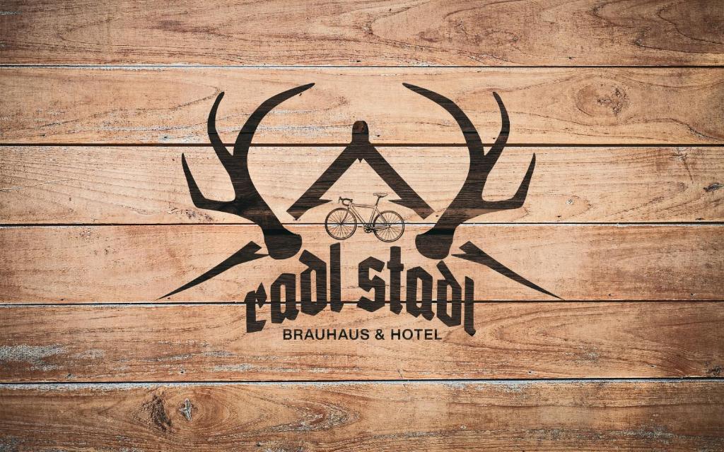 a antler sign on a wooden wall with a bike at RadlStadl - Brauhaus und Hotel in Kaarst