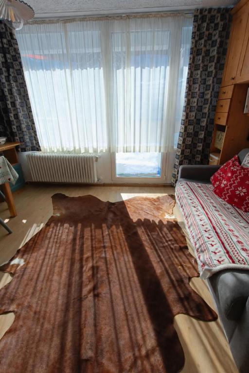 a living room with a large rug on the floor at Lo Gnomo Apartment in Marilleva