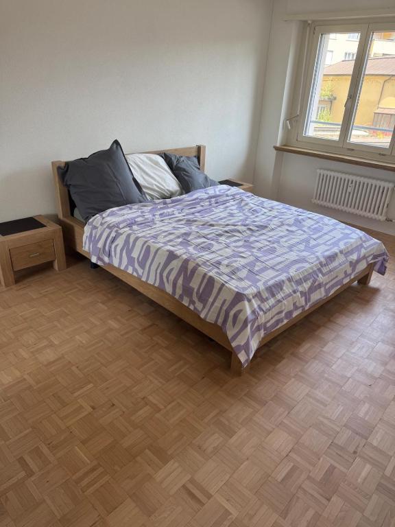 a bedroom with a bed and a wooden floor at Shared Apartment in central Luzern in Lucerne