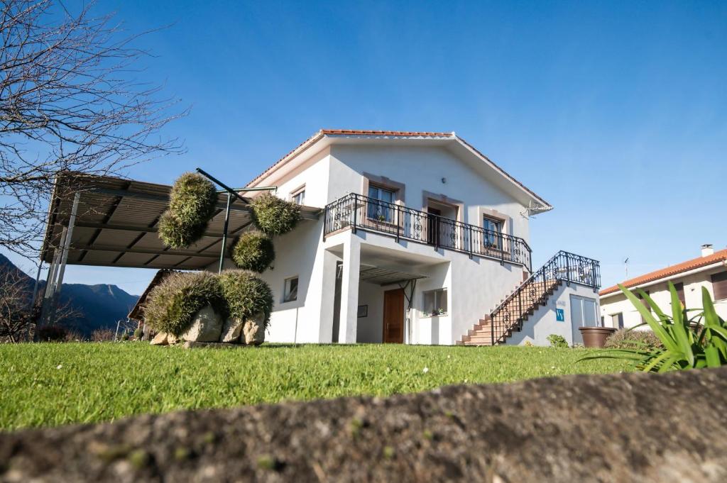 a white house with a balcony and a yard at Casa vacacional El Angel in La Pesa