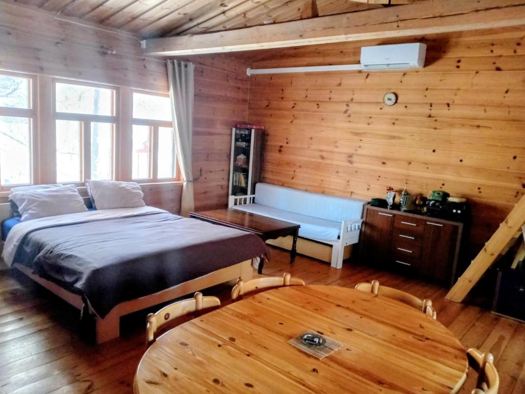 a bedroom with a bed and a wooden wall at Riverside Cottage Äänekoski Sauna Hot Tub Northern Lights in Äänekoski