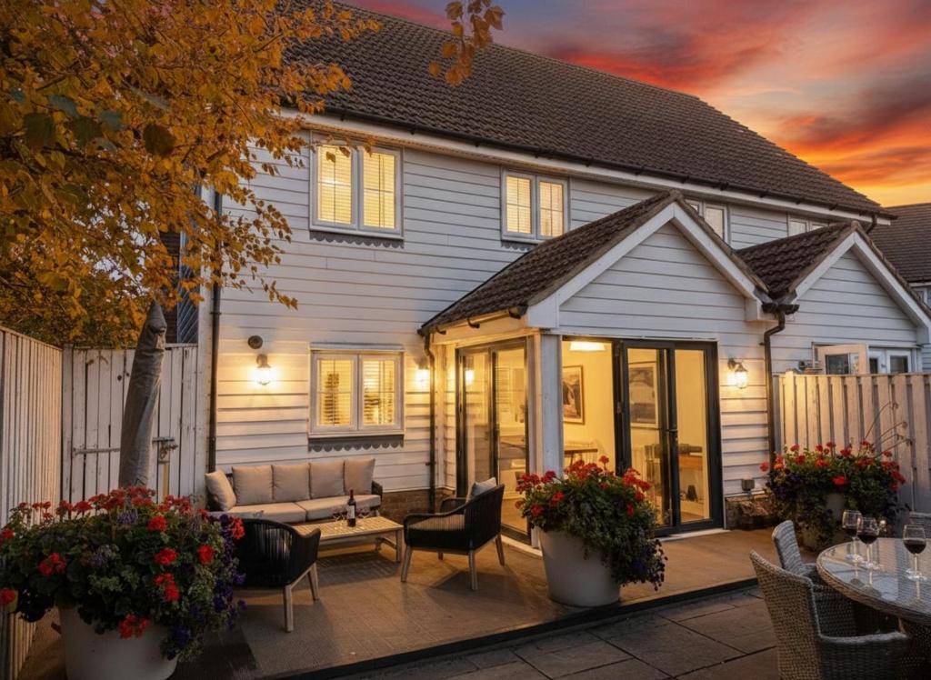 a house with a couch and chairs on a patio at The Light House in Camber