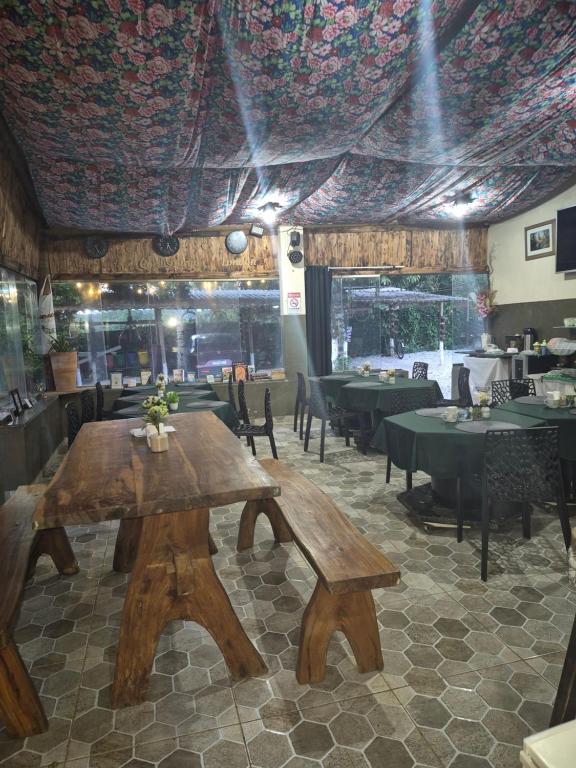 a restaurant with a wooden table and tables and chairs at Pousada Casa Verde in Cordisburgo
