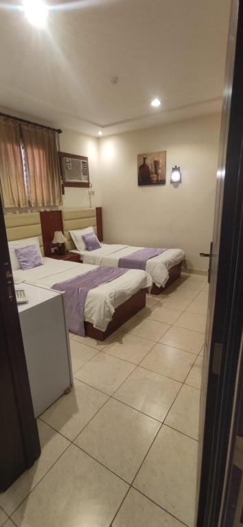 a hotel room with two beds in a room at عمارة النفيسة شقة 18 in Unayzah