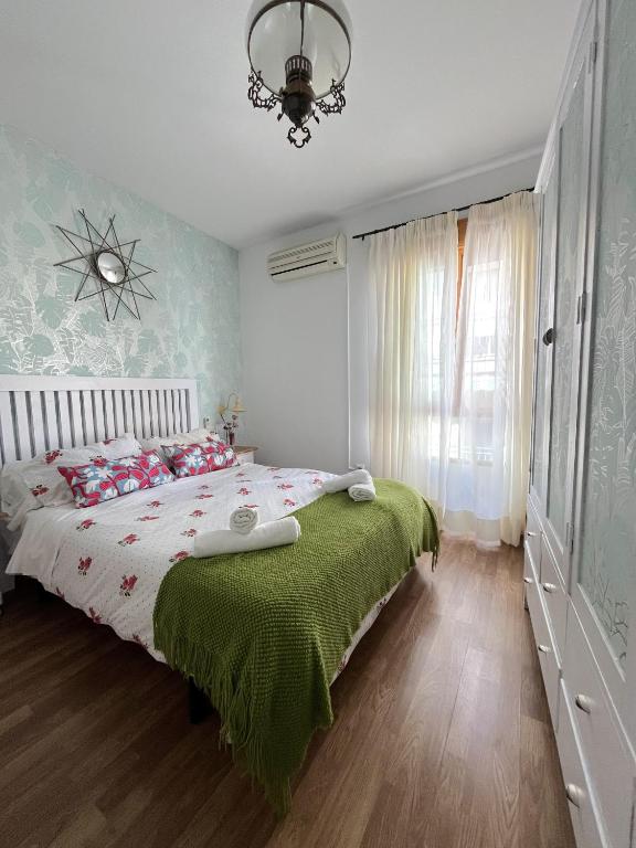 a bedroom with a bed with a green blanket at The Llanete Collection 01 in Martos