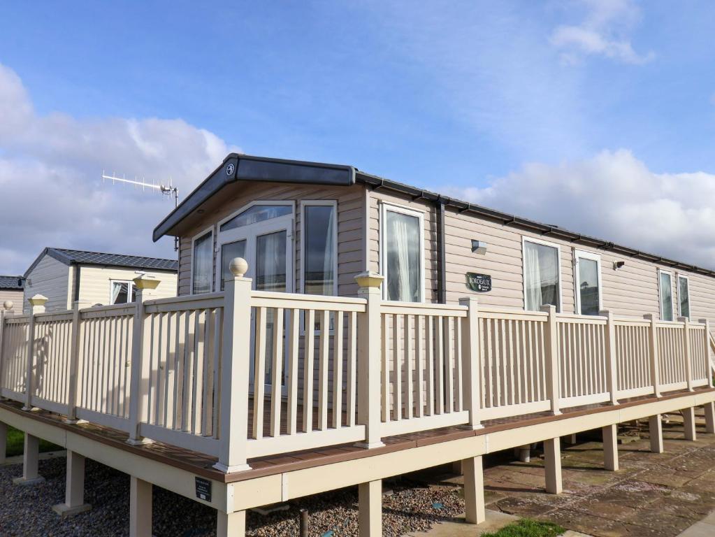 a tiny house on a wooden deck at Caravan B14 Beechrise in Filey