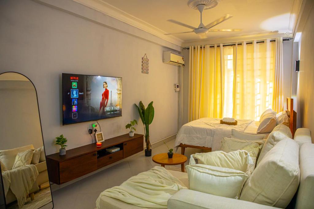 a living room with a couch and a tv at Nyumbani 2 studio in Dar es Salaam