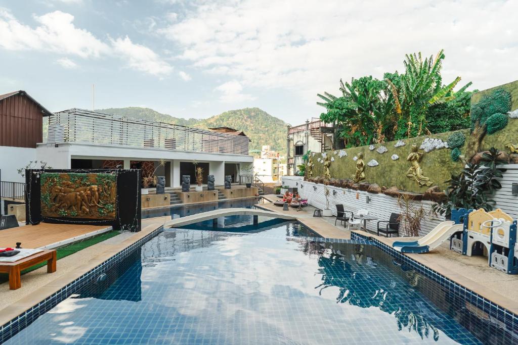 a pool at a resort with mountains in the background at Patong hillside Condo with pool, bar, parking in Patong Beach