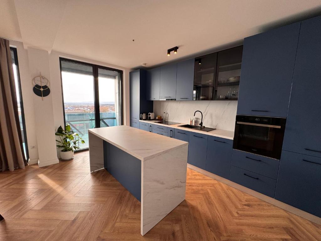 eine Küche mit blauen Schränken und einer Arbeitsplatte in der Unterkunft Panoramic Blue in TÄƒuÅ£ii MÄƒgheruÅŸ