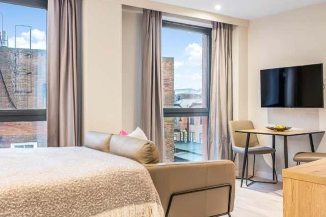 a hotel room with a bed and a large window at Central Studios In Lincoln with Free Grab&Go Breakfast in Lincoln