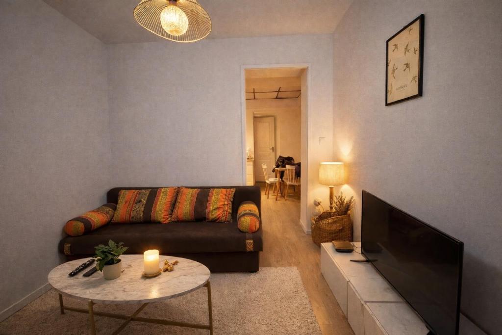 a living room with a couch and a table at Le cocon avec Terrasse in Amiens
