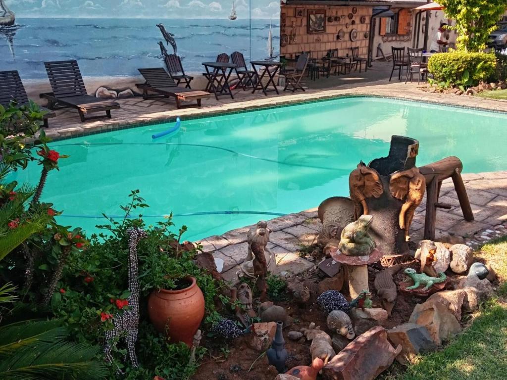 a small swimming pool with a statue next to it at Petra Lodge in Edenvale