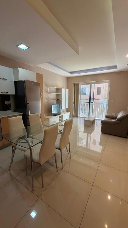 a large living room with a glass table and chairs at Oasis Apartment in Sliema
