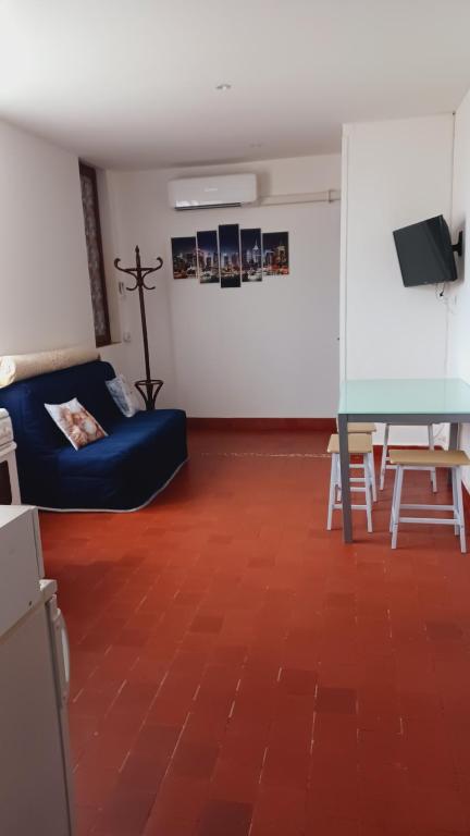 a living room with a blue couch and a table at Bel Appartement Fonctionnel,2 grandes chambres separer plus un bz,WI FI,Clim in Digoin