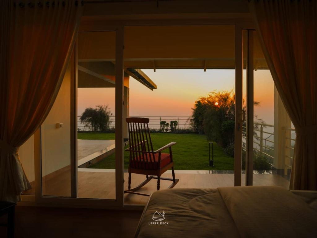 a bedroom with a bed and a view of the ocean at The Upper Deck in Pīrmed