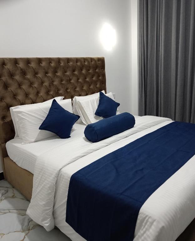 a blue and white bed with blue pillows on it at Samiru Guest Inn Ella in Ella