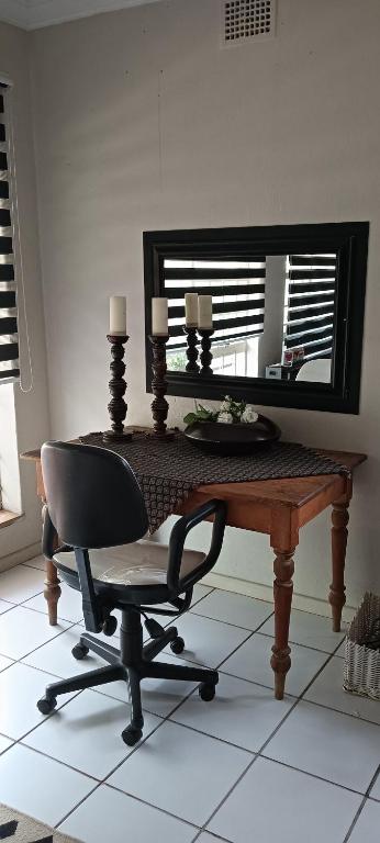 a desk with a chair in front of a mirror at Meltz Inn in Klerksdorp