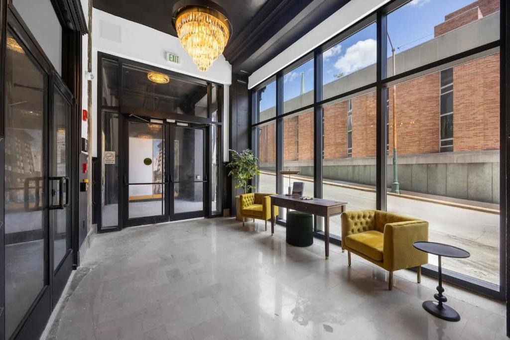 a lobby with yellow chairs and a table and windows at Park Hotel Studio Suite 403 in Chattanooga