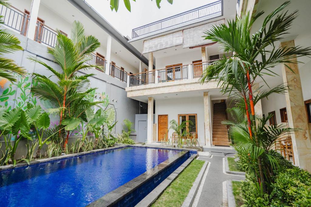 an image of a villa with a swimming pool and palm trees at Kayuma House Canggu in Canggu