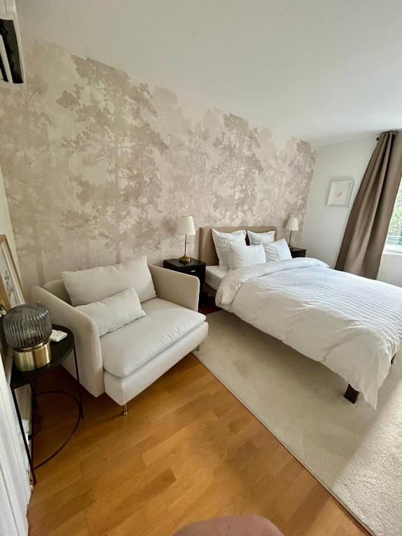 a bedroom with a bed and a couch and a chair at Suite JULIETTE Chambre d'hôte de charme in Mulhouse