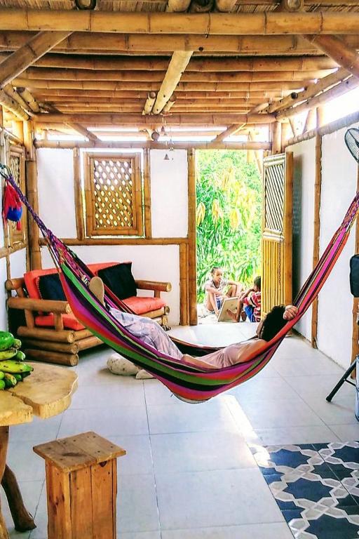 a man laying in a hammock in a room at Casa de Guadua in Dibulla