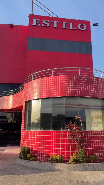 a red brick building with a red sign on it at Hotel Estilo in Arapiraca