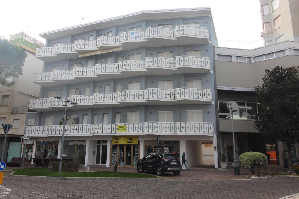 a building with a car parked in front of it at Residence Rondinelle in Lignano Sabbiadoro