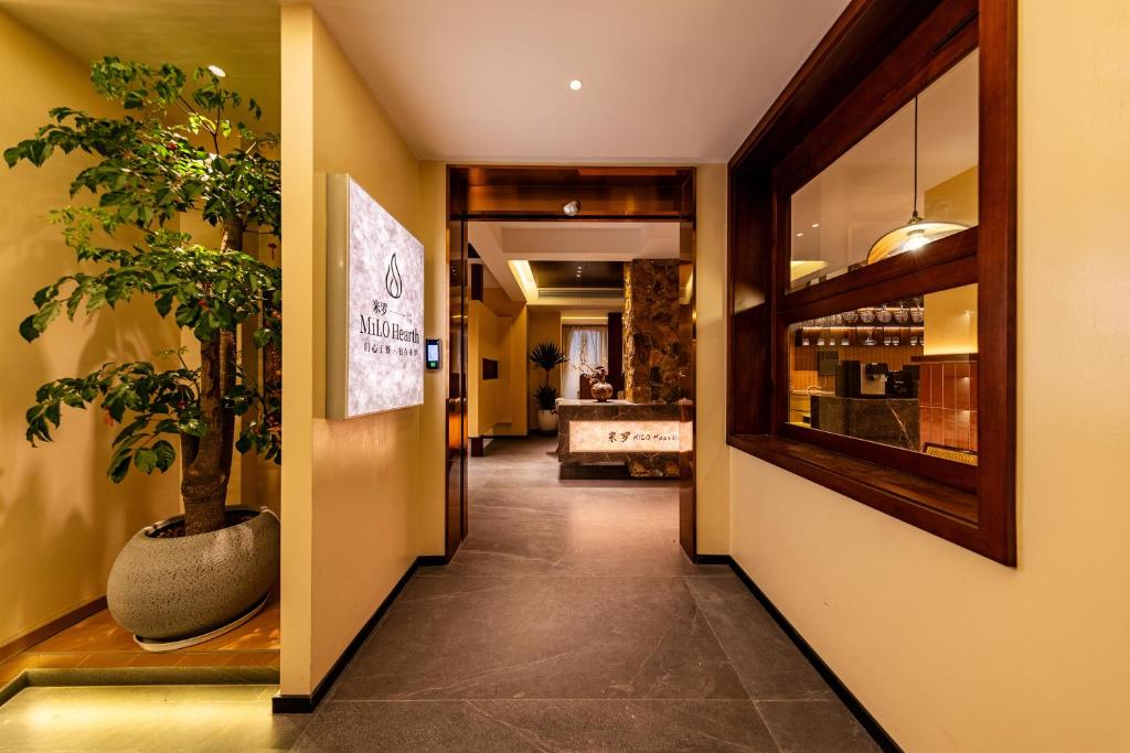 a hallway with a plant in a vase next to a door at MiLO Hearth米罗设计民宿 张家界天门山索道店 in Zhangjiajie