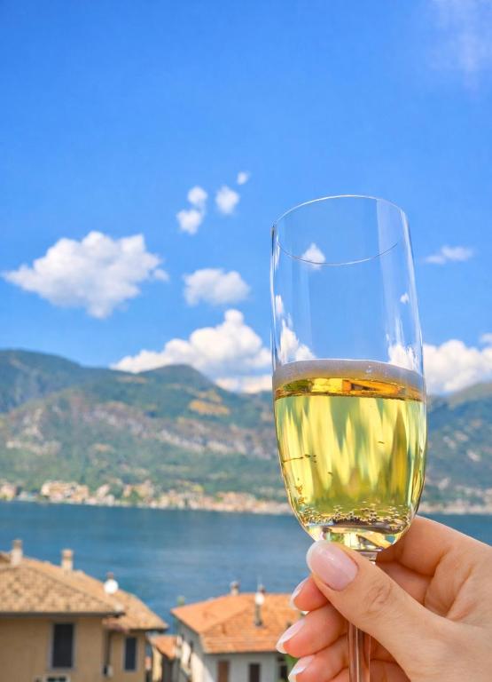 a person holding a glass of white wine at Il Gerlo in Lezzeno