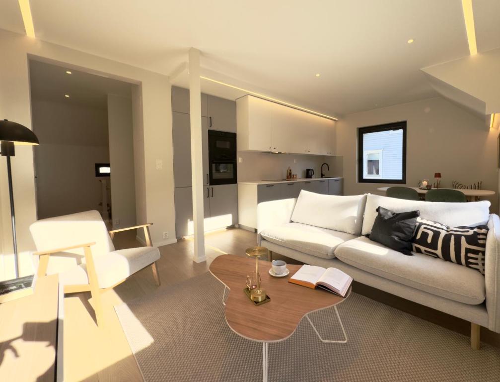 a living room with a white couch and a table at Odda Gangdal Apartments in Odda