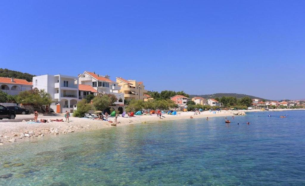 a beach with a bunch of people in the water at Apartmani Suzi in Slatine