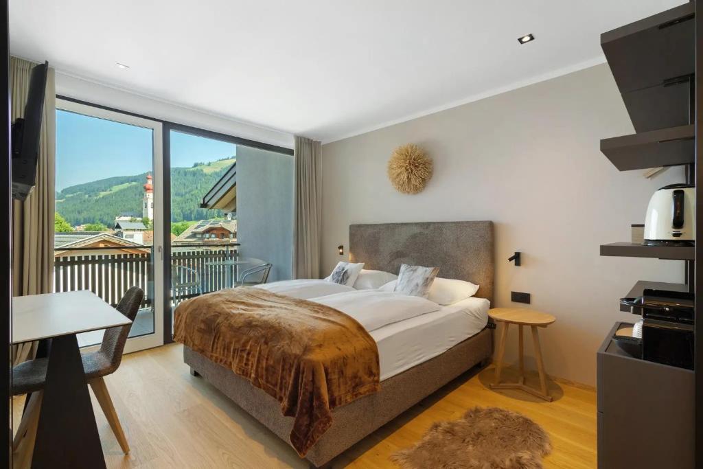 a bedroom with a large bed and a balcony at Appartment Hofer Room Bergnest in Villabassa