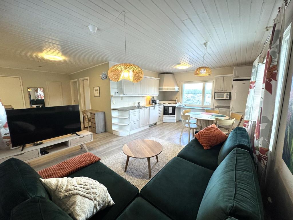 a living room with a couch and a table at Riihen Pirtti in Äkäslompolo