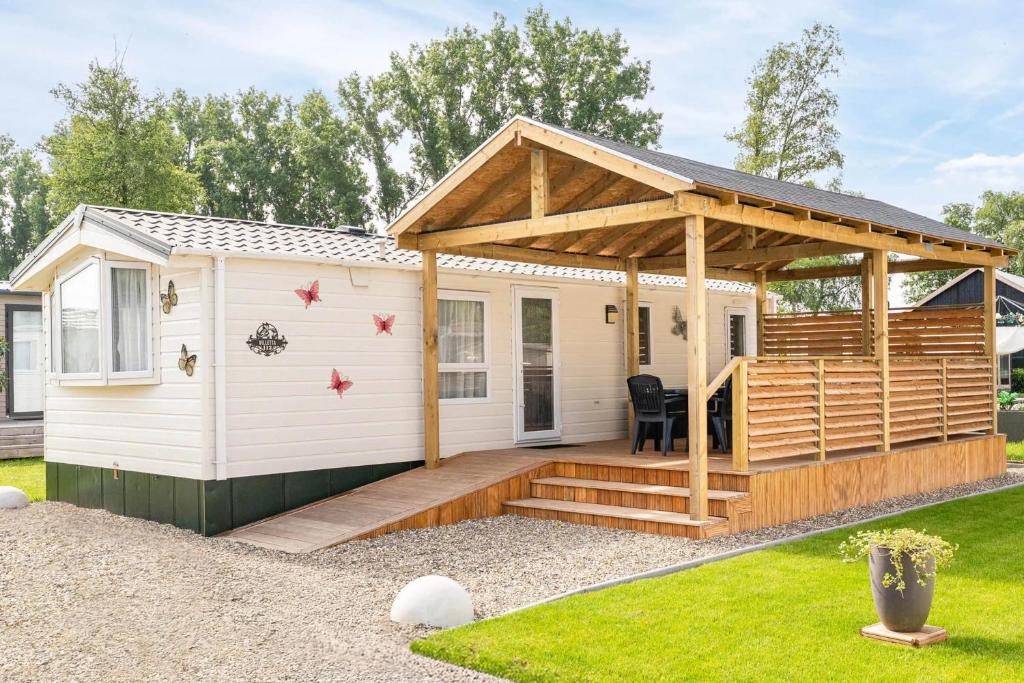 a tiny house with a deck and a pergola at Camping Papillon Kinrooi 113 in Kinrooi