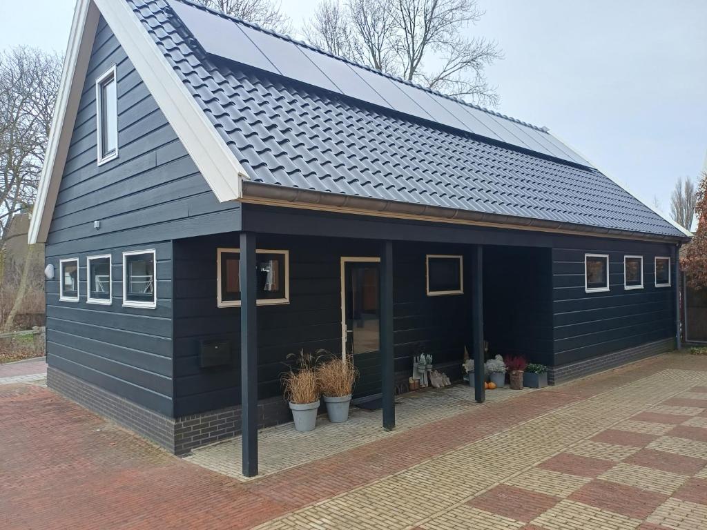 a blue house with a solar roof on it at Hannes in Schagen
