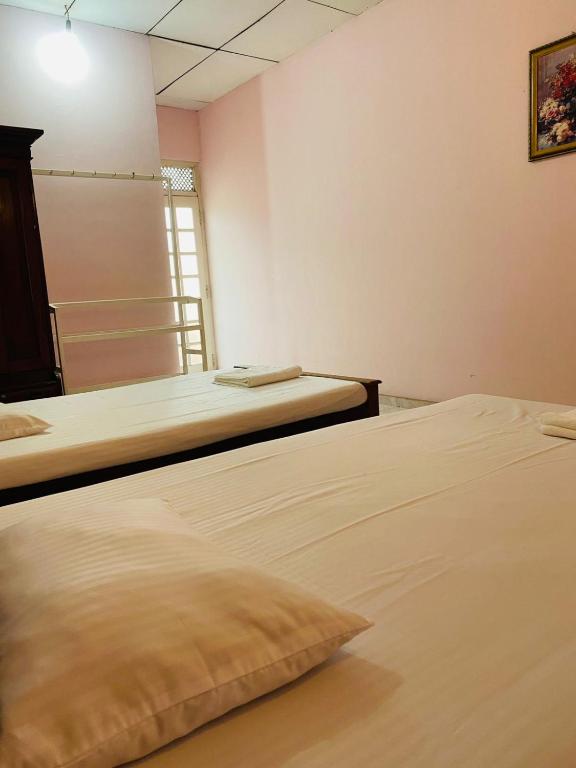 a bedroom with two beds and a window at SAMA TOURIST guest in Seeduwa