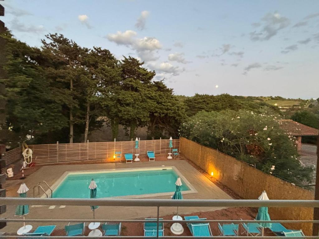 a swimming pool with blue chairs around it at Acquaviva Suites, Pool - View in San Vincenzo
