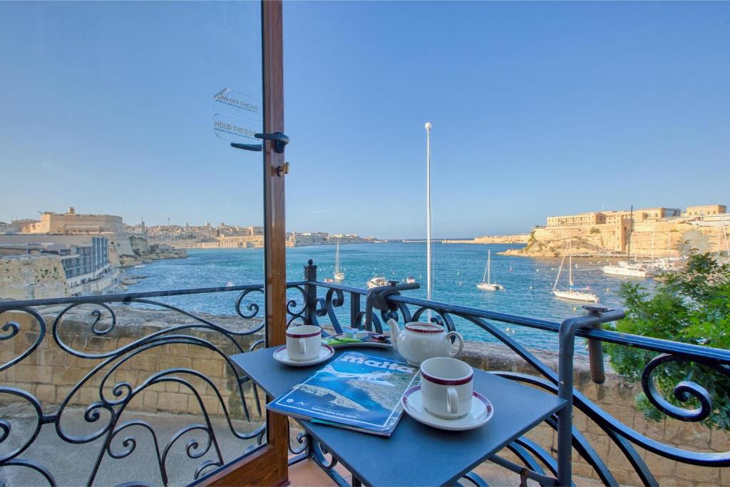 a balcony with a table with a view of the water at Charming City Stay close to Seafront in Birgu